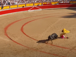 Imagen de un torero arrodillado ante un toro usada para ilustrar la expresión Salir por pies en el blog Expresiones del español.