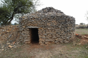 Casa diminuta hecha de piedras en una imagen usada para ilustrar la expresión genio y figura.