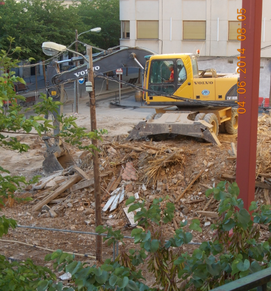 Imagen de materiales de derribo junto a una excavadora, usada dicha imagen para ilustrar la expresión material de derribo.