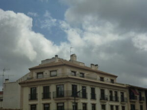 Edificio bajo nubes que presagian tormenta en una imagen usada para ilustrar la expresión paciencia y barajar.